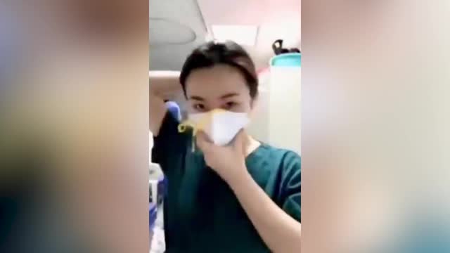 Медсестра из Китая надевает спецодежду, чтобы лечить пациентов
