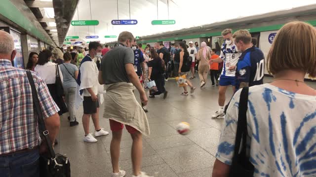 Финские болельщики играют в футбол в метро Петербурга