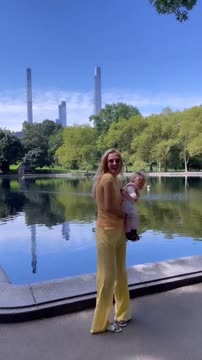 Жена Медведева качает дочку Алису на руках у озера в Нью-Йорке