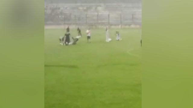 Игрока, который умер от удара молнии, уносят с футбольного поля