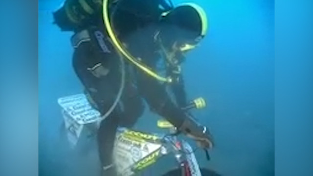 Подводный байкер едет на велосипеде на глубине 60 метров
