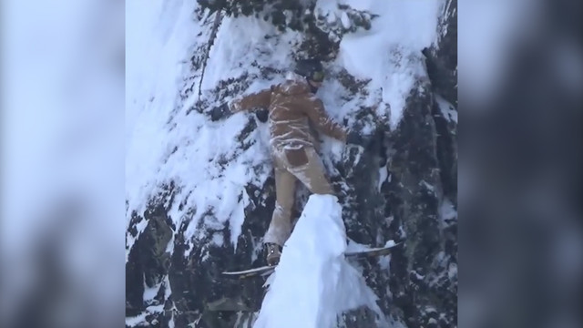 Сноубордист нелепо и опасно застрял на скале. И как не упал?